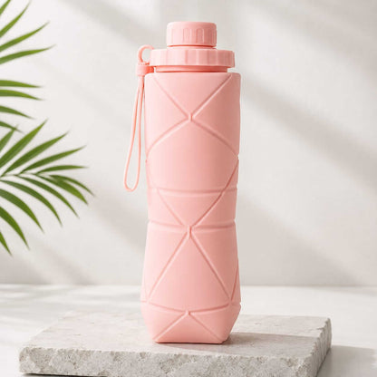 Collapsible silicone water bottle in soft pink with geometric fold design and leak-proof cap