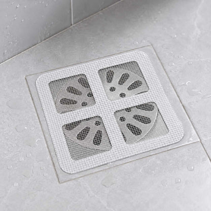 Disposable drain hair catcher mesh sticker placed over a bathroom floor drain