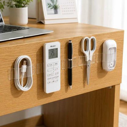 Double-sided tape holding remotes, scissors, and cables neatly on a desk edge
