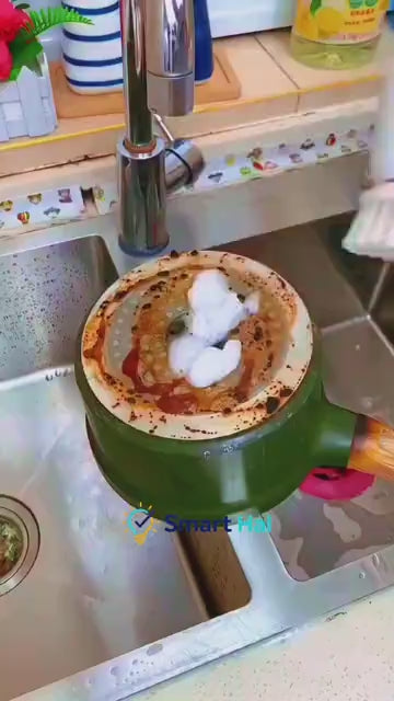 Electric cleaning brush scrubbing a sink and cookware